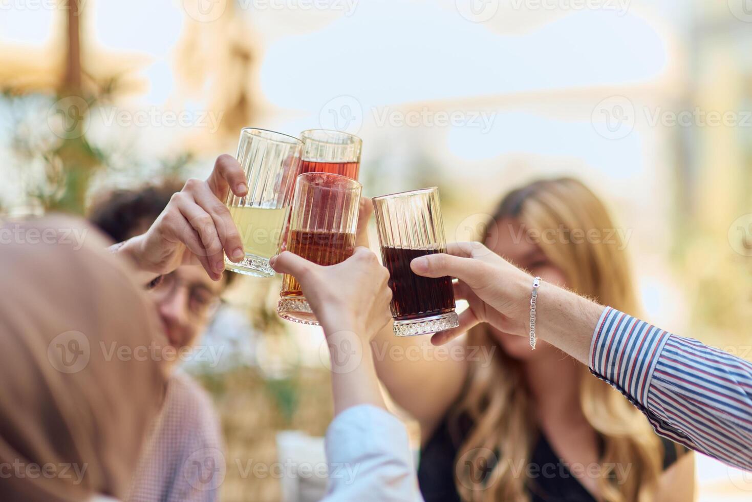 A diverse group of friends sitting together in a cozy cafe, smiling and raising their glasses in a joyful toast, celebrating friendship and good times photo