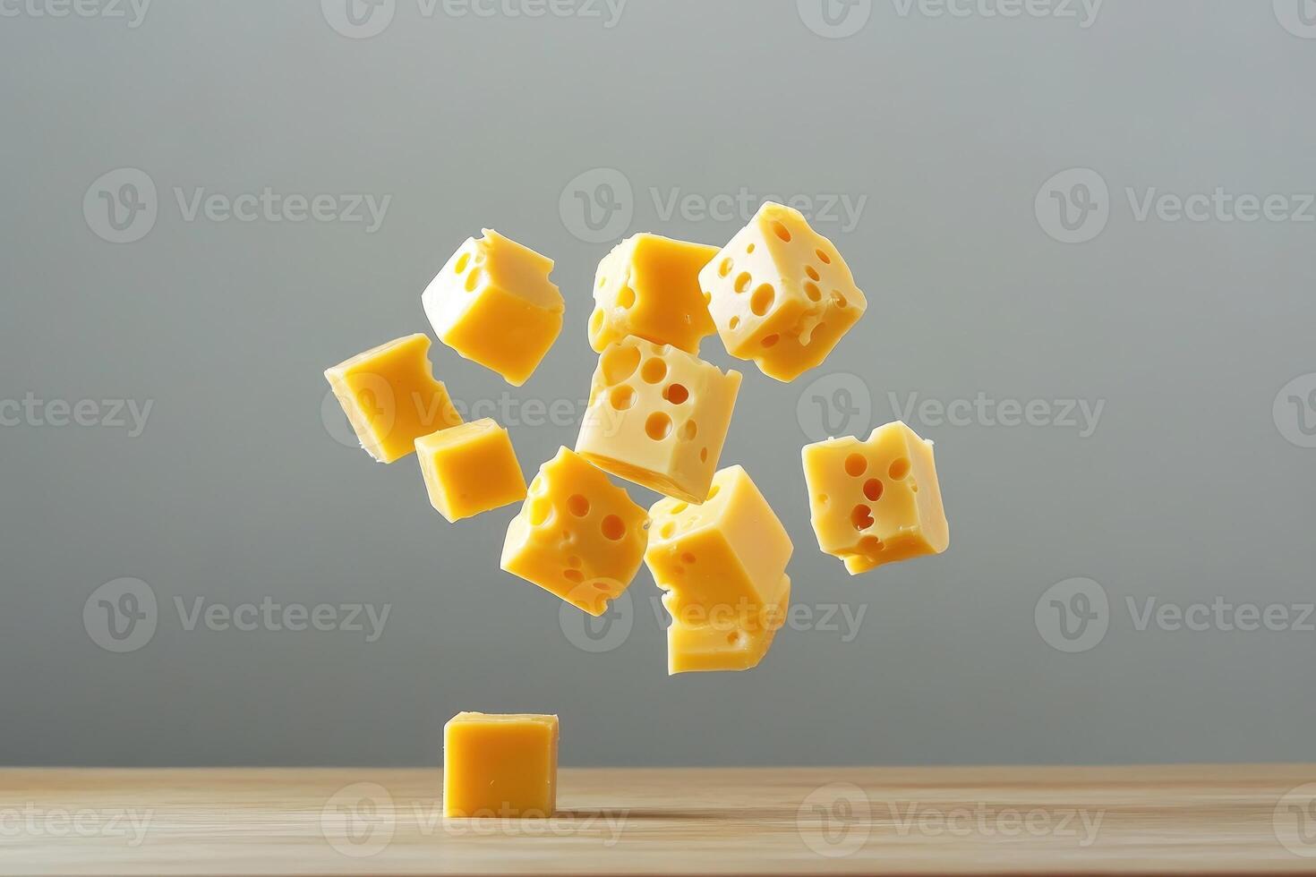 Cubes of Swiss Cheese Falling Towards a Wooden Surface photo