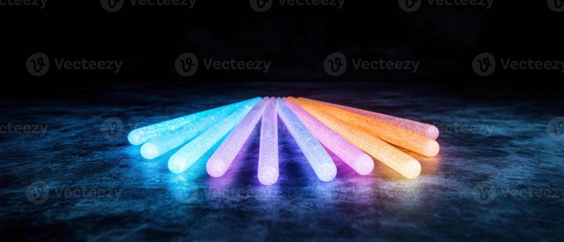Colorful glowing sticks on dark background photo