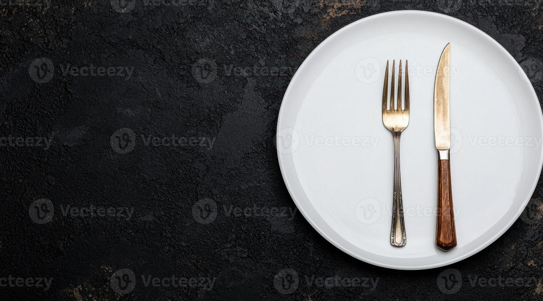 elegant dining setting with white plate and cutlery on dark background photo