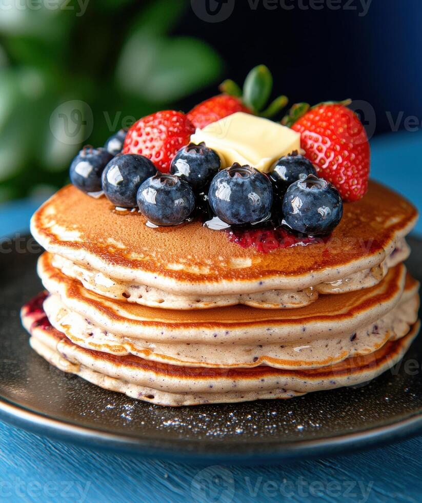 Delicious stack of pancakes with fresh berries and butter photo
