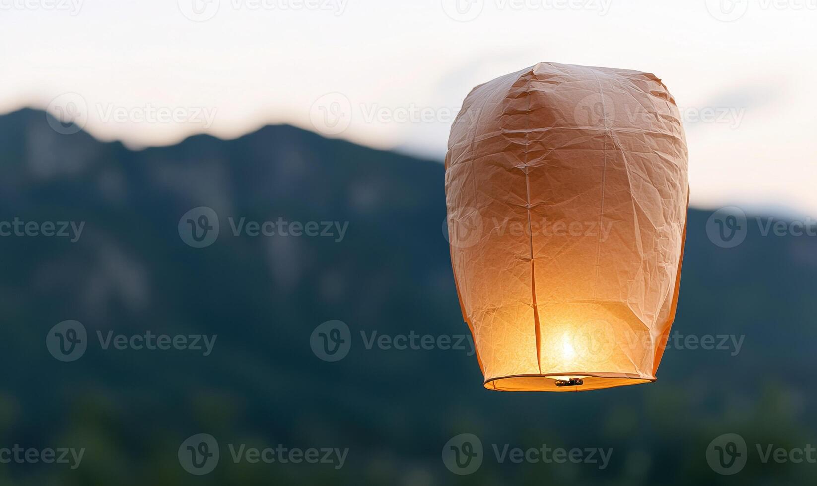 Glowing paper lantern in the mountains at sunset photo