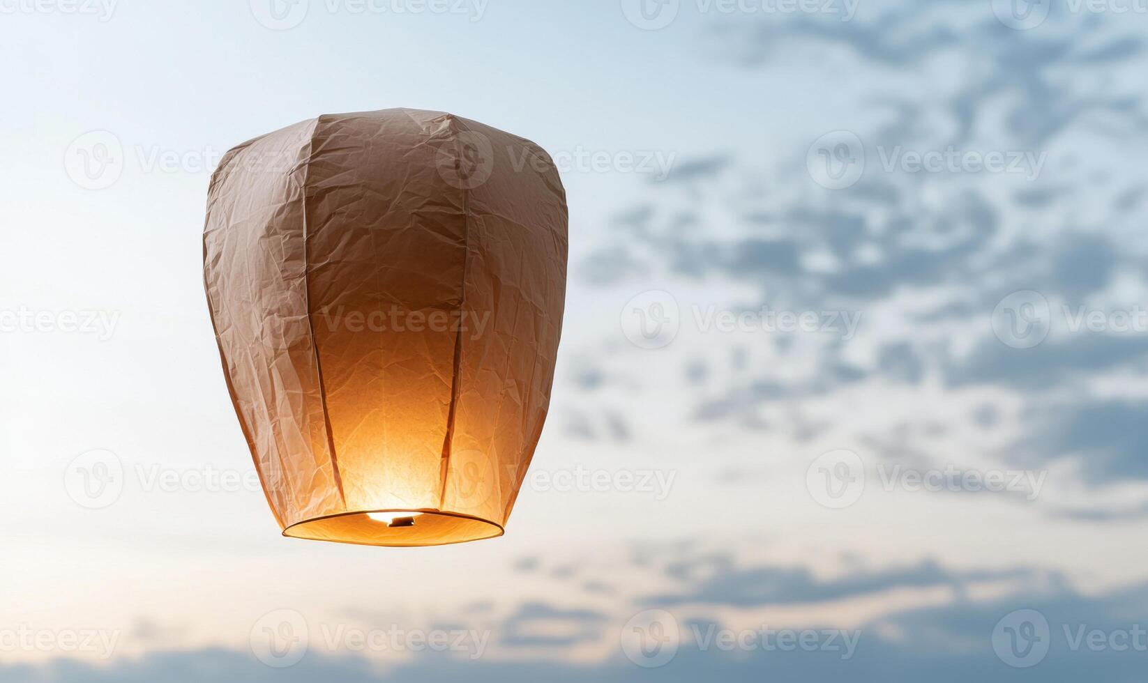 Glowing paper lantern floating in the sky photo