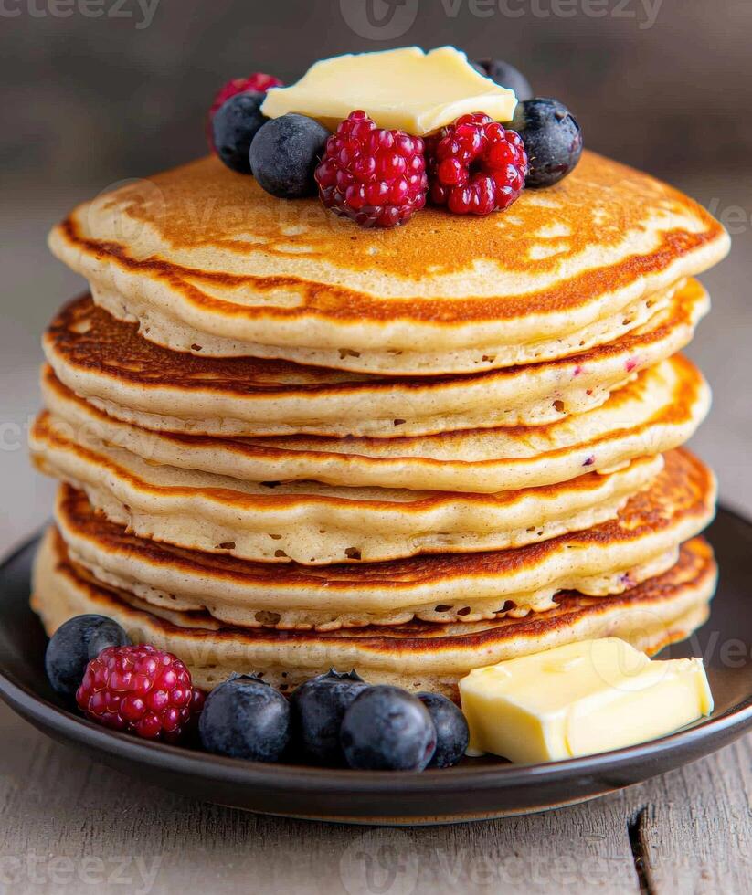 Delicious stack of fluffy pancakes topped with fresh berries and butter photo