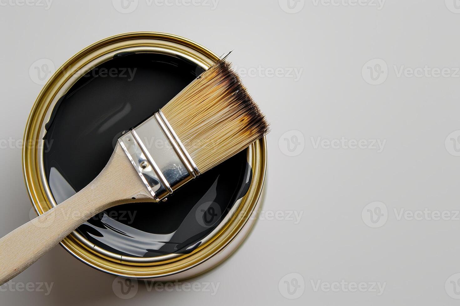 Painting with a brush in a can of black paint photo
