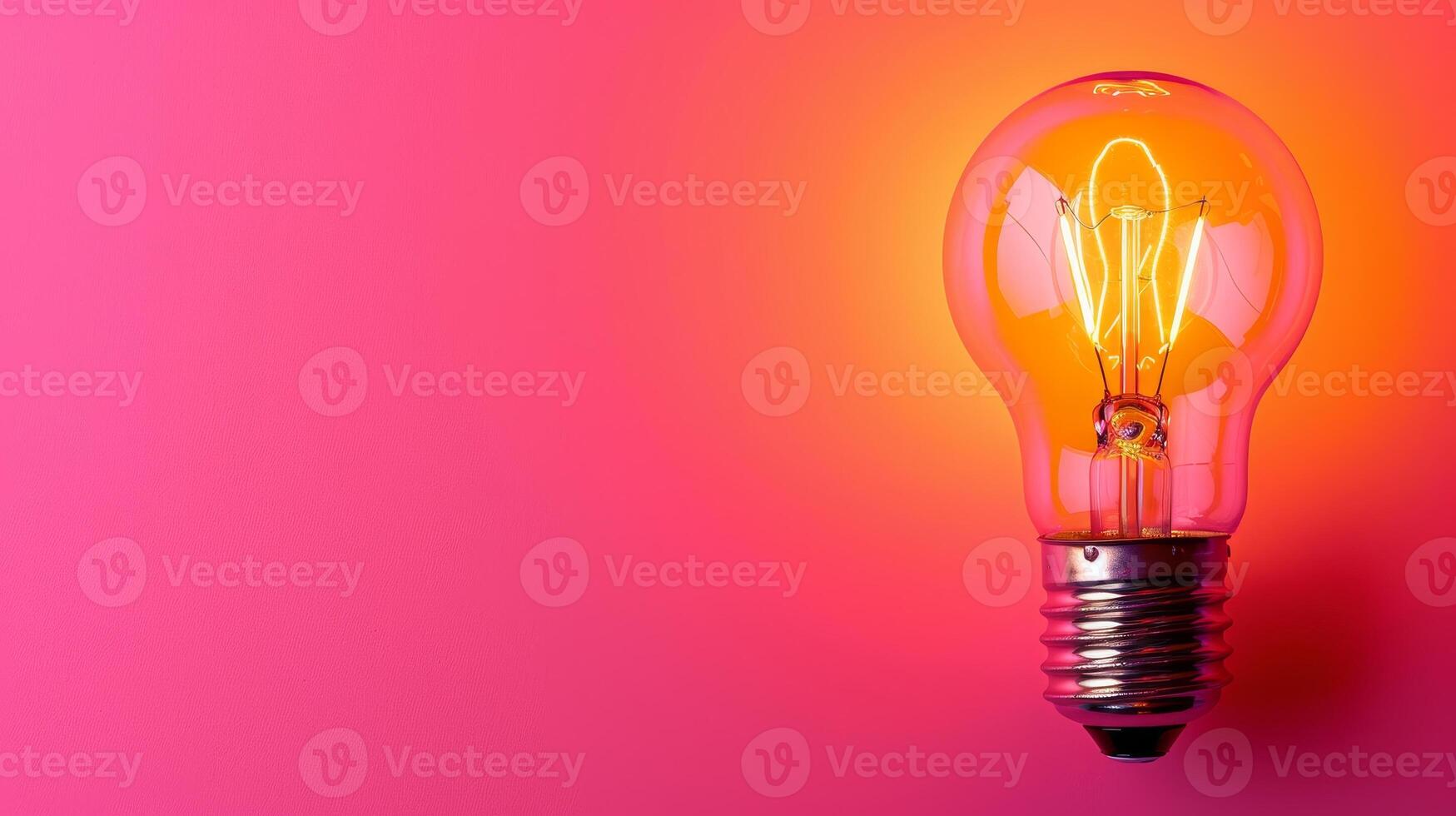 Glowing light bulb on vibrant pink and orange background photo