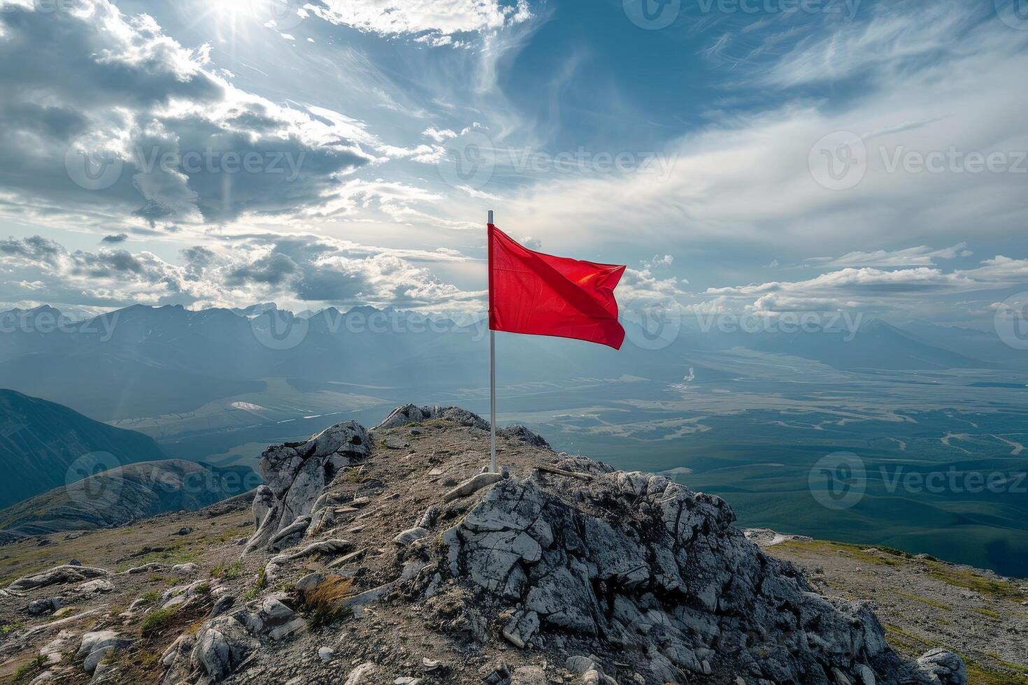 Red flag on mountain peak with dramatic cloudy sky photo