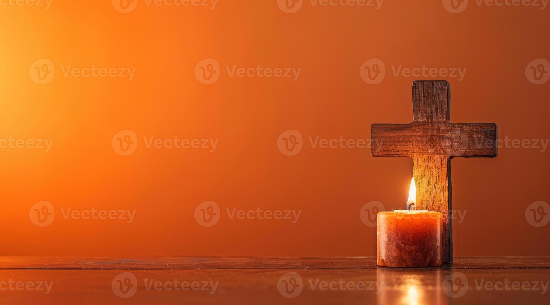 Wooden cross and candle on a warm background photo
