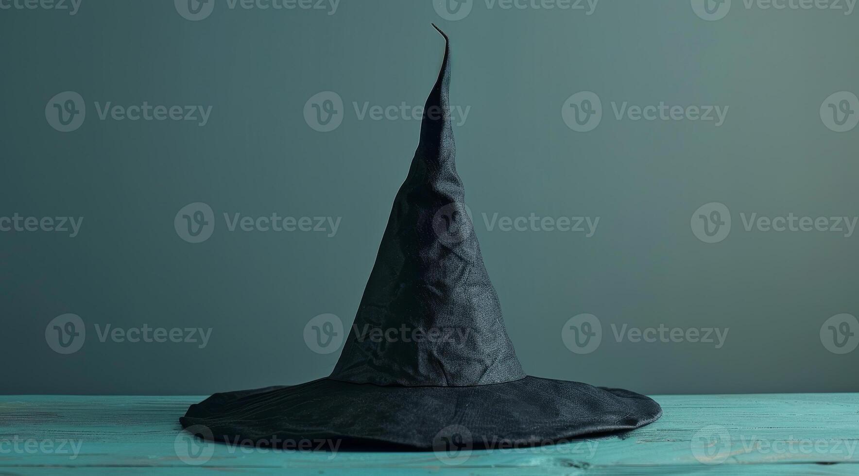 Mysterious black witch hat on a wooden table photo
