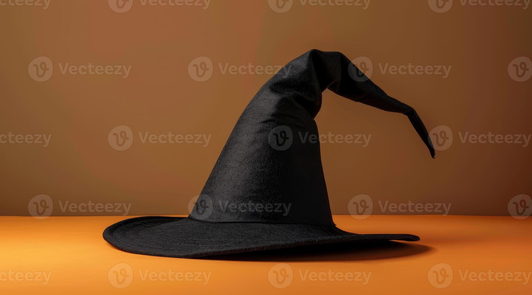 Classic black witch hat on an orange background photo