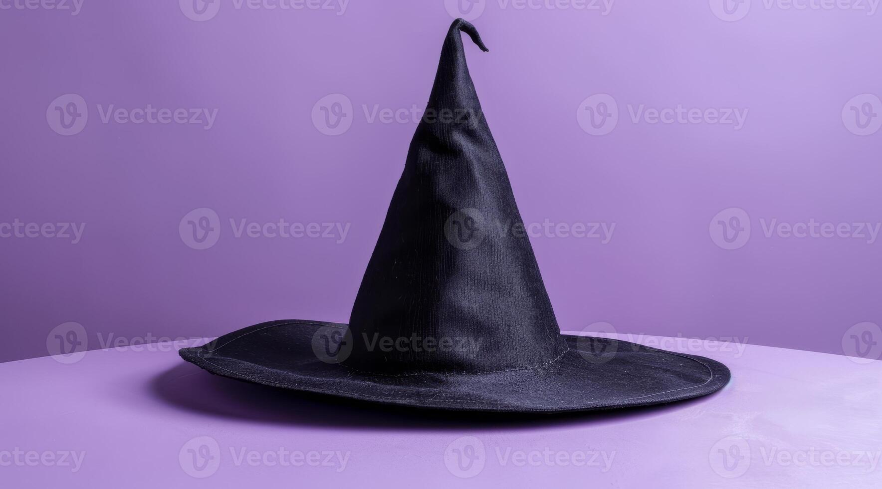 Black witch hat on a purple background photo