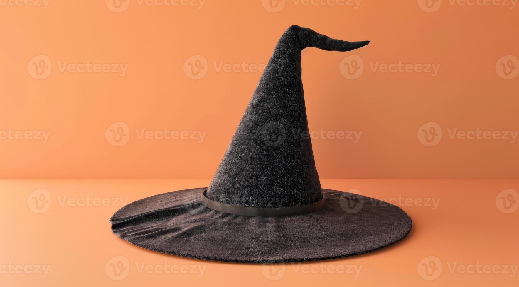 Classic black witch hat on an orange background photo