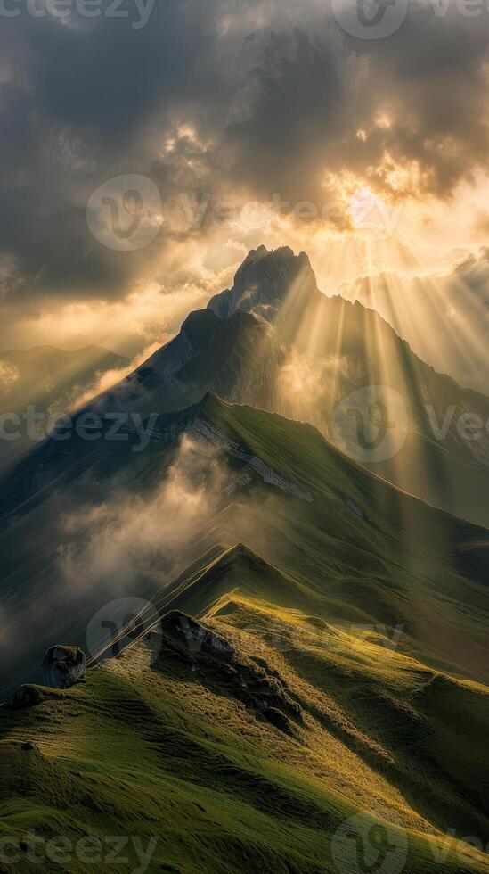 Sunrays breaking through clouds over majestic mountain peaks photo