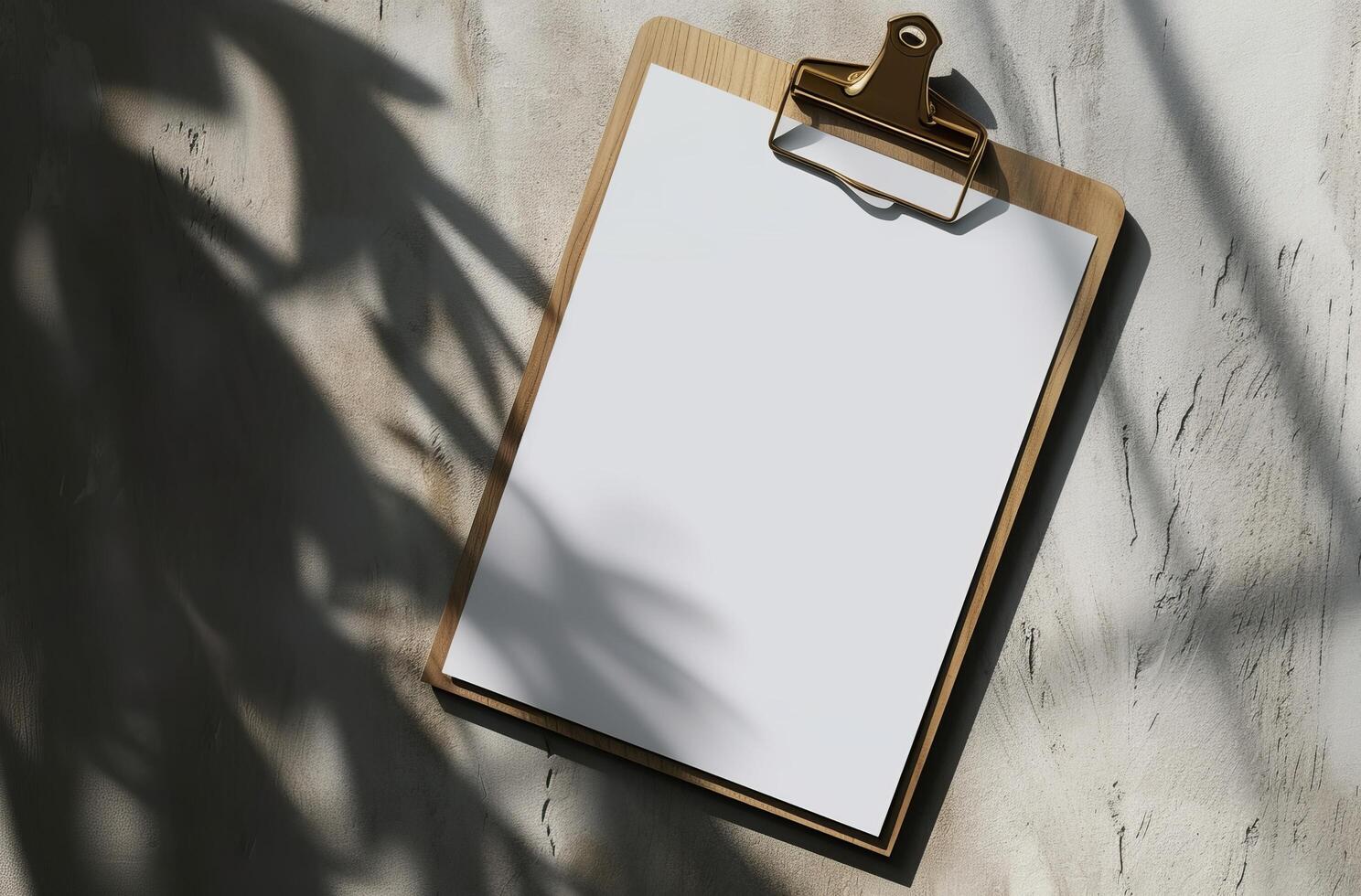 Blank clipboard on a textured background with natural shadows photo