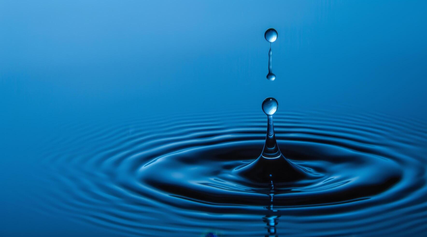 Perfect water droplet creating ripples on serene blue surface photo