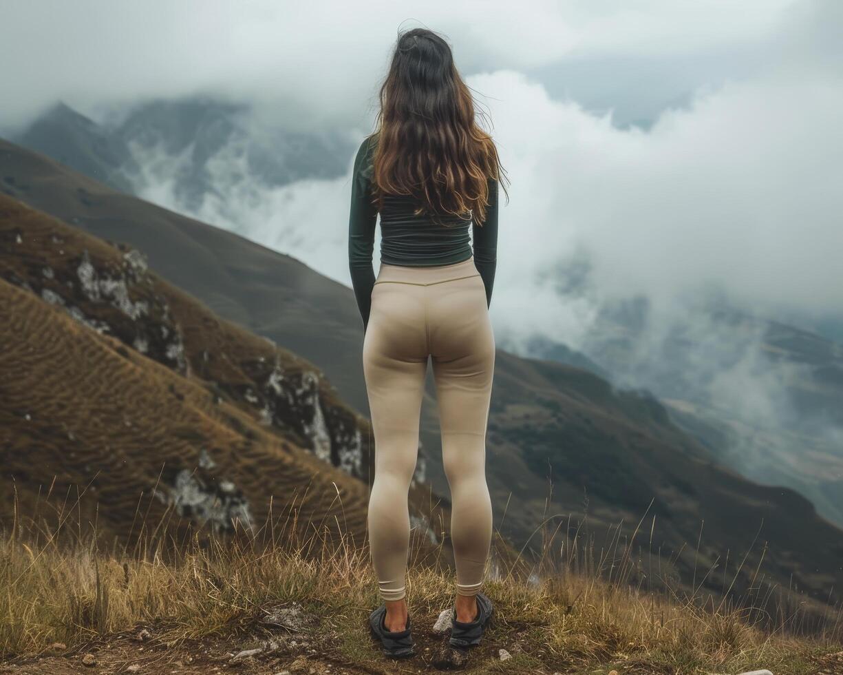 Woman standing on mountain summit overlooking clouds photo