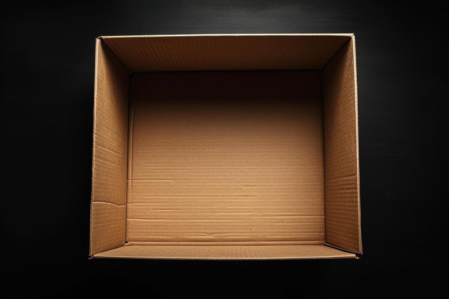 Open empty cardboard box on a black background photo