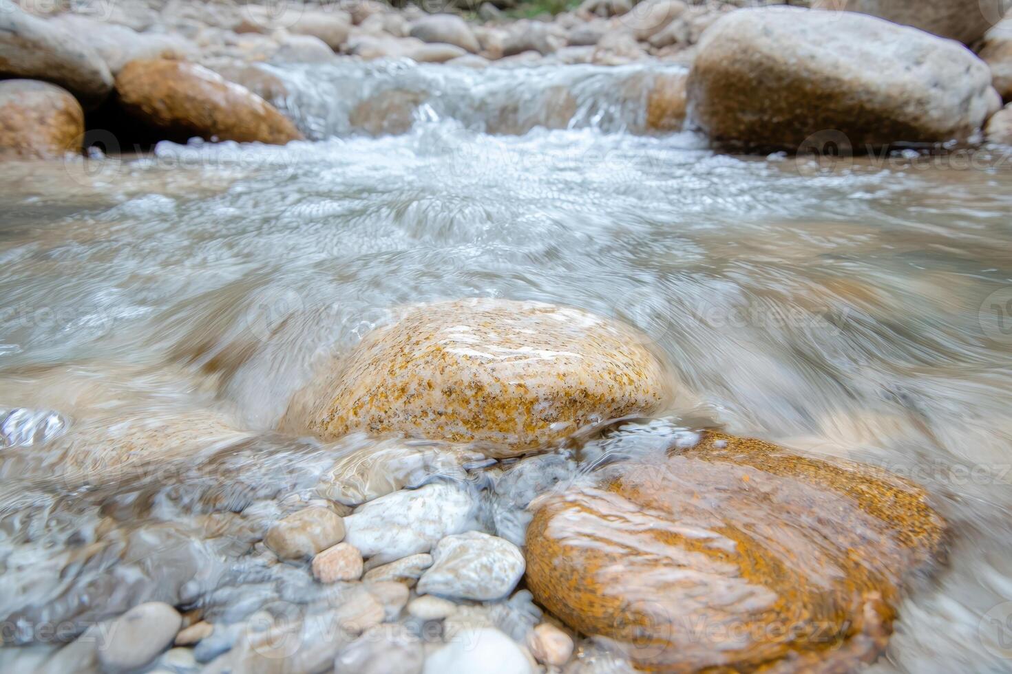 flowing stream with rocks and pebbles photo