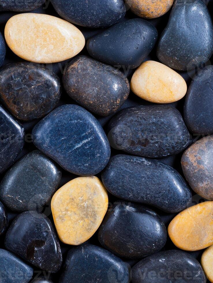 Smooth river rocks in various shades of gray and orange photo