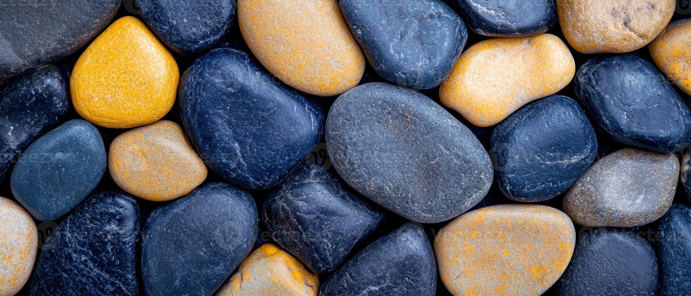 Smooth river rocks in various shades of gray and orange photo