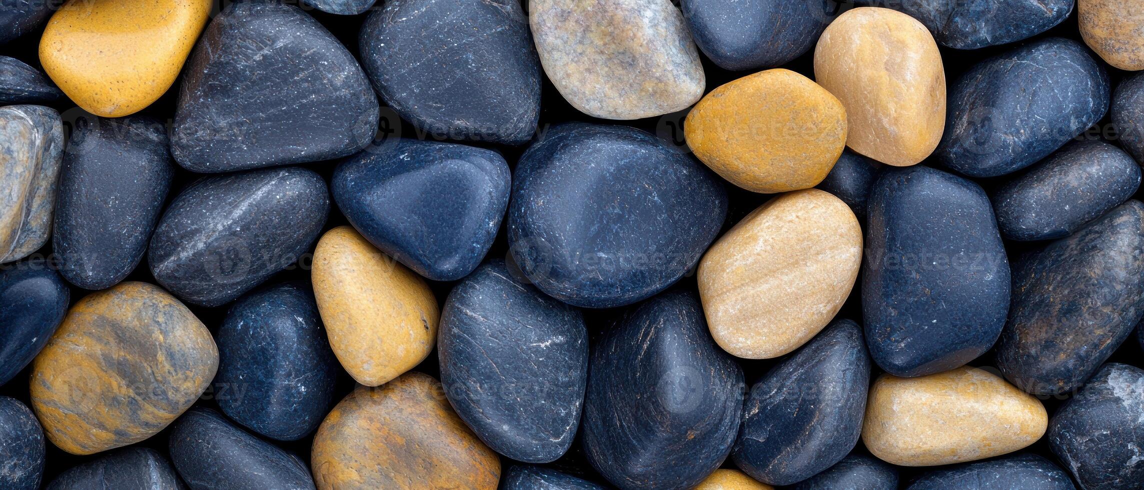 Smooth river rocks in various shades of gray and yellow photo
