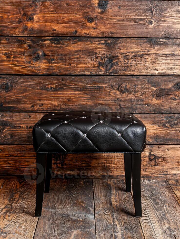 black leather tufted ottoman on rustic wood floor photo