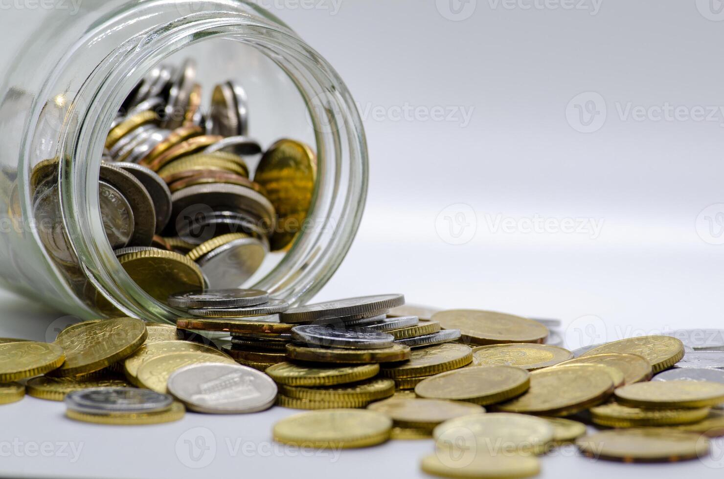 Coins in a jar with white background representing business, investment or any monetary concept. Customizable space for text photo