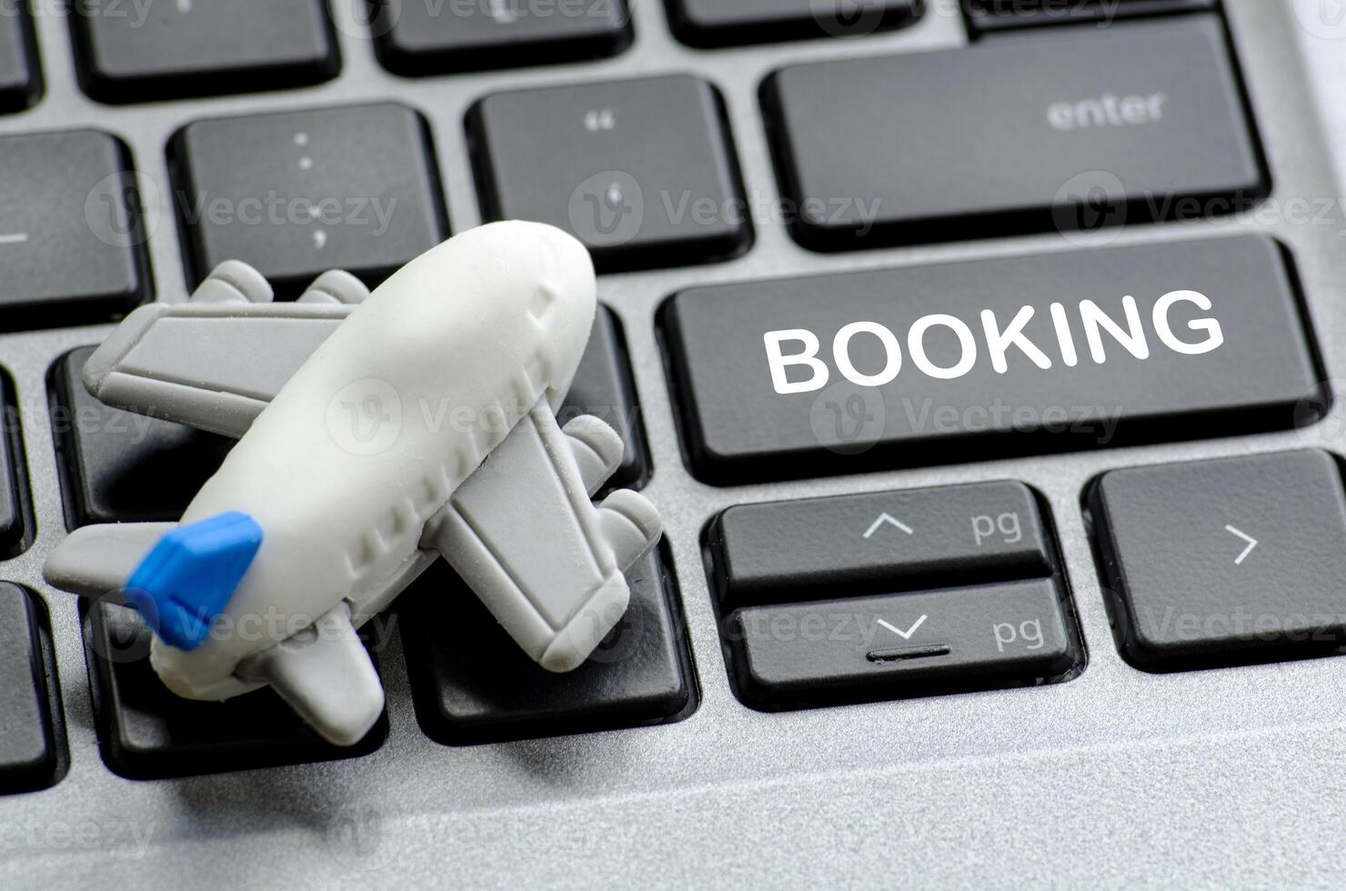 Booking text on laptop keyboard with airplane toy. Travel and destination concept photo