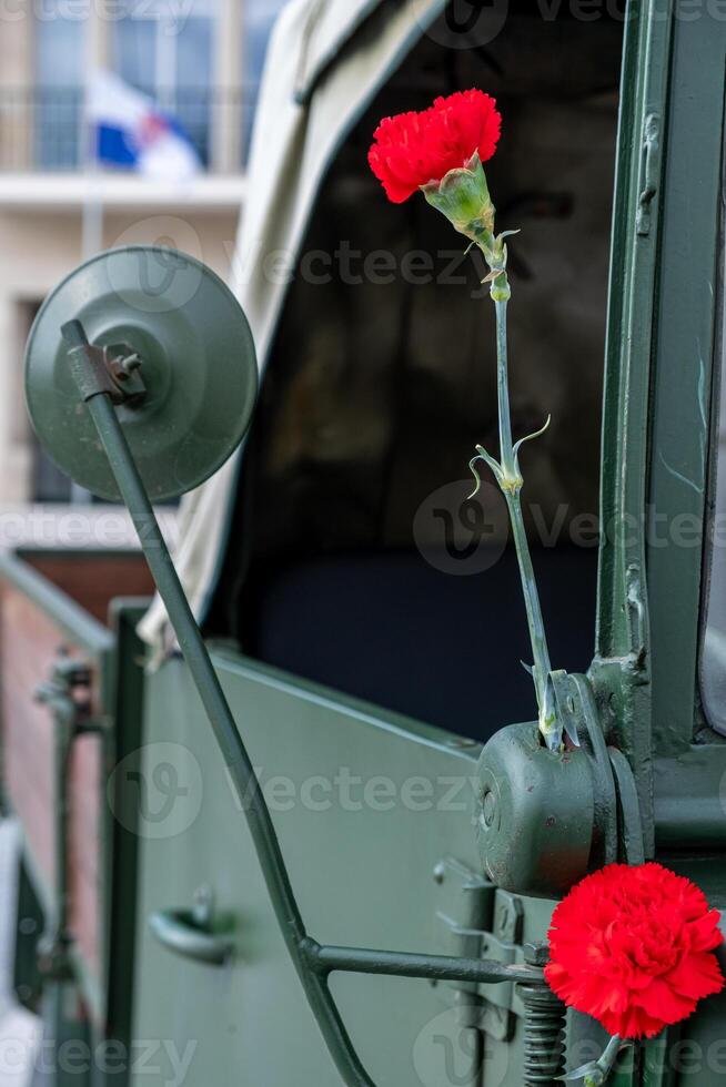 two red carnations decorating a military vehicle during the commemoration of April 25th in Portugal. Revolucao dos Cravos. photo