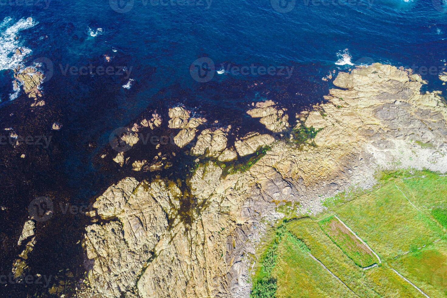 rocky shore of a rocky coast and agricultural fields, aerial view with drone, background for coastal concept photo