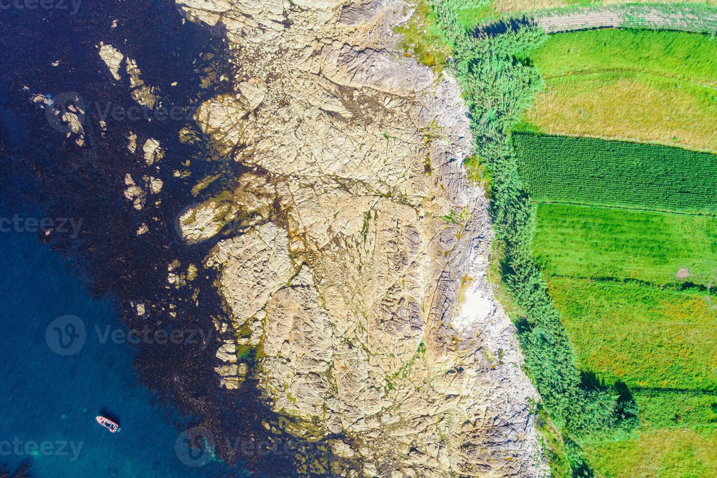 edge of a rocky shore, aerial view with a rocky shore of a rocky coast and agricultural fields, aerial view with drone, background for marine concept photo