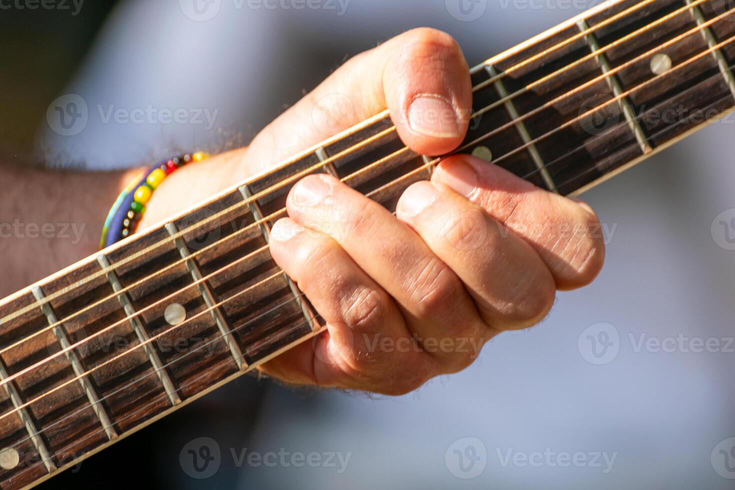 detailed shot of musician's hand on the fretboard of a spanish guitar, creating music, music concept background photo