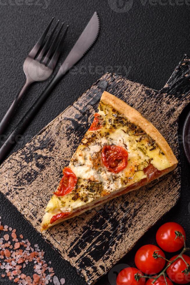 Delicious crispy quiche cut into slices with cheese, broccoli, tomatoes photo