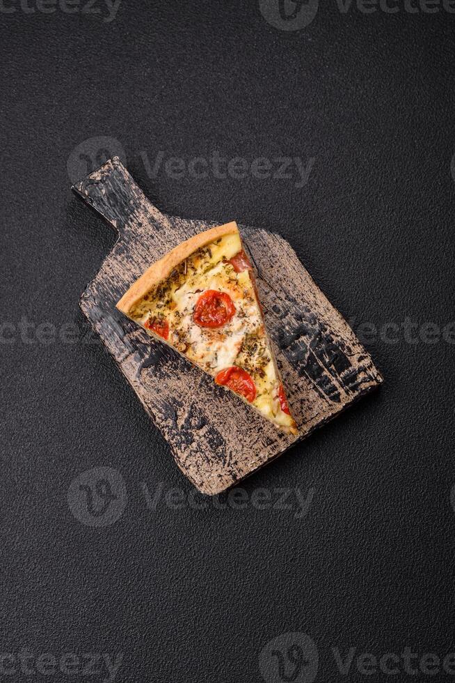 Delicious crispy quiche cut into slices with cheese, broccoli, tomatoes photo