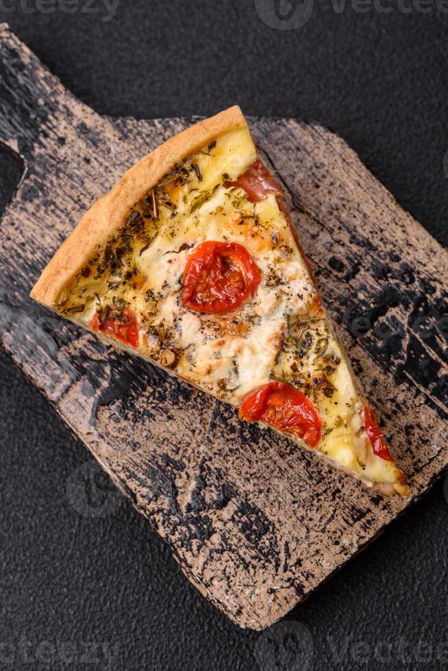 Delicious crispy quiche cut into slices with cheese, broccoli, tomatoes photo
