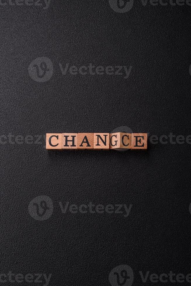 The inscription chance or change with wooden cubes on a dark concrete background photo