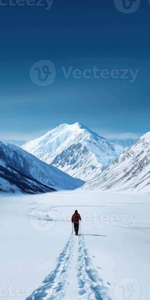 Hiking through snow-covered valley towards majestic mountain photo