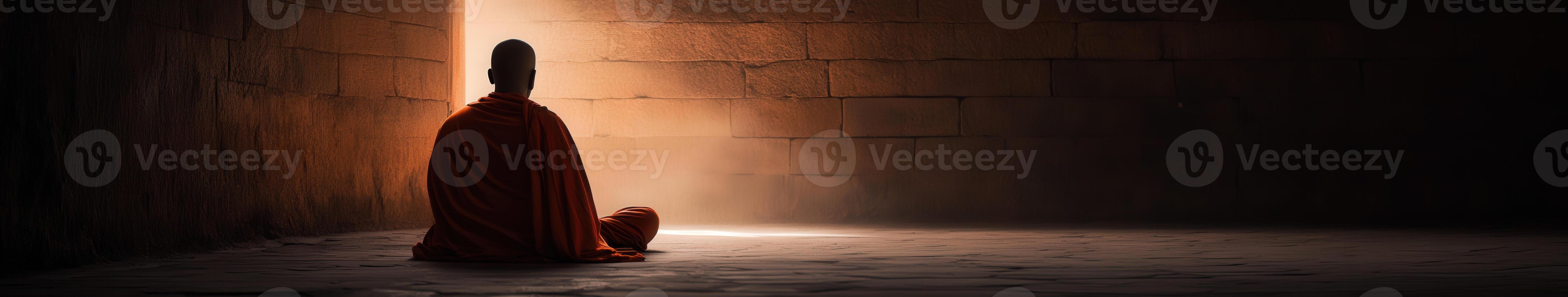 Monk meditating in a dimly lit ancient temple photo