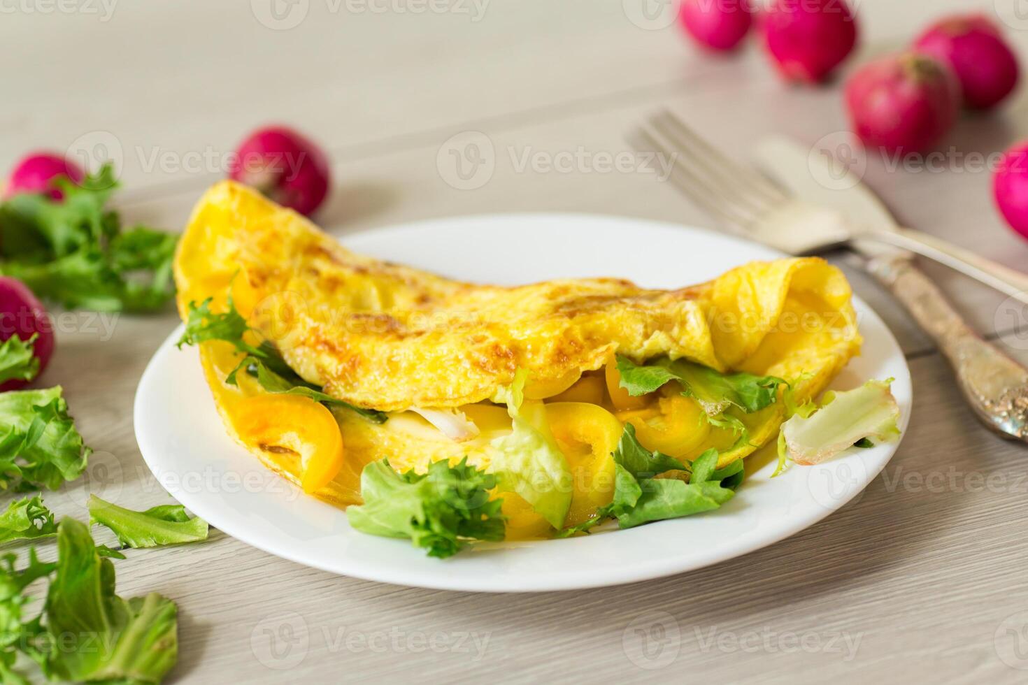 egg roll with sweet pepper and salad, on a wooden table photo