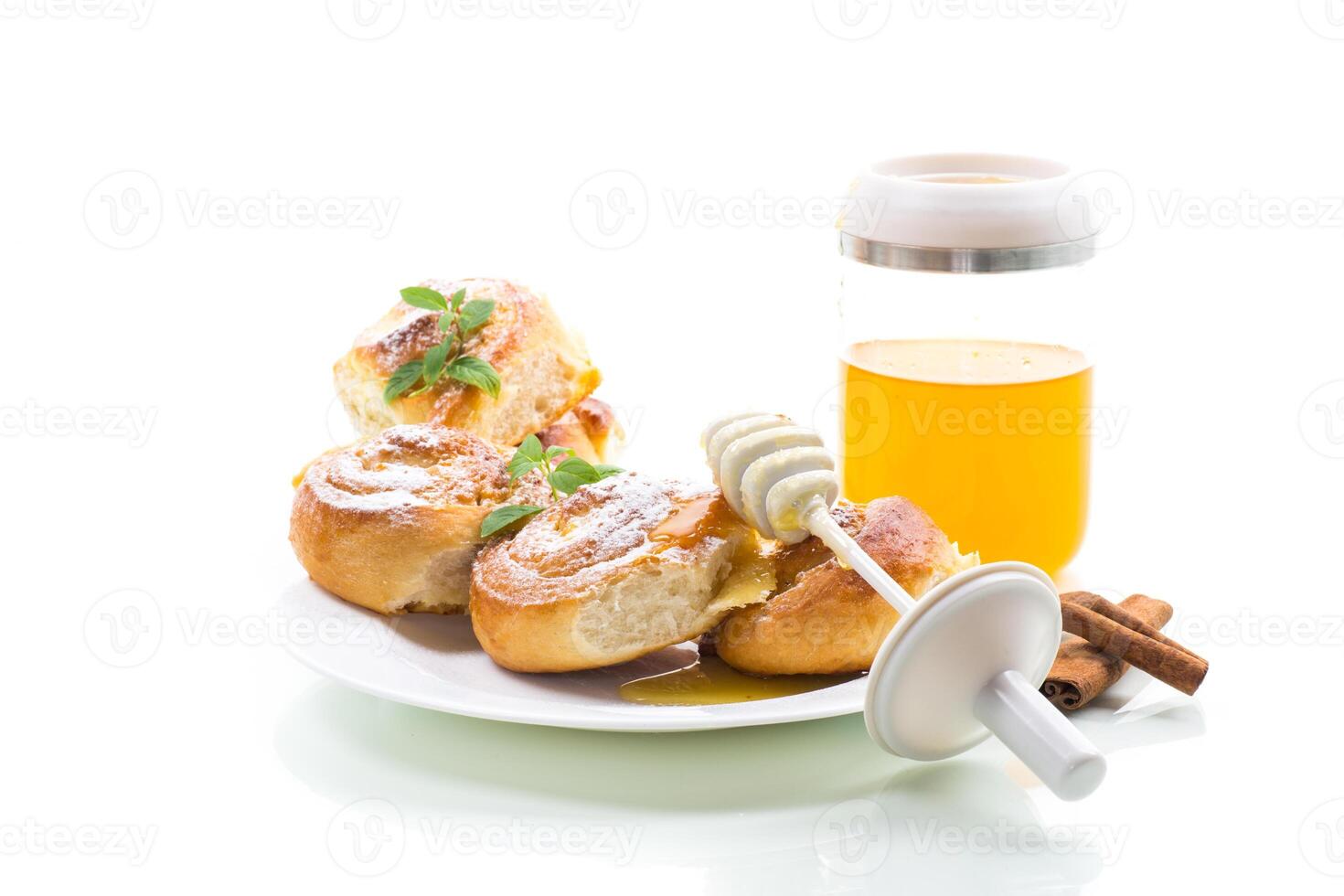 Baked goods. Sweet buns with cottage cheese filling and honey in a plate isolated on a white background photo