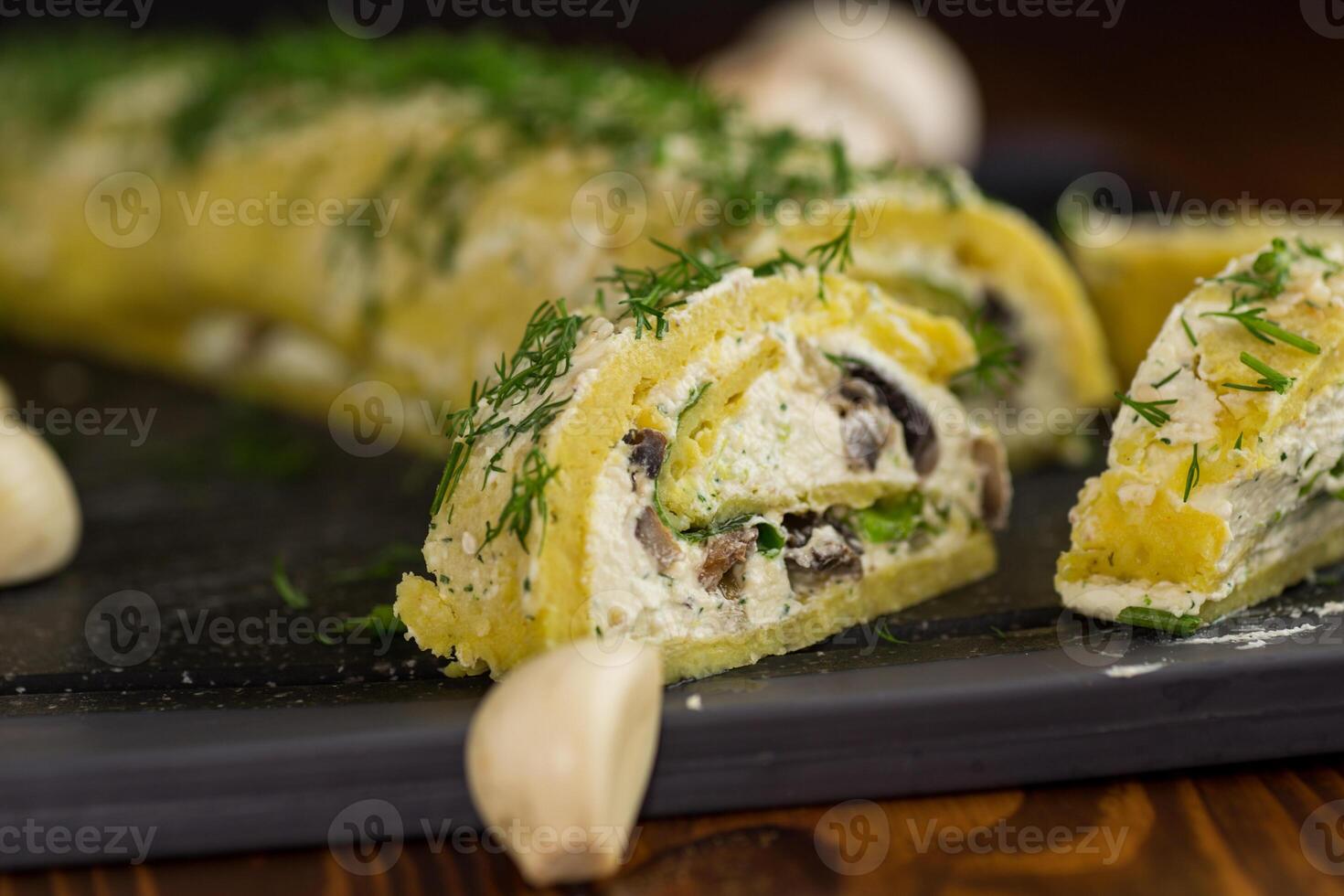 baked potato roll with cottage cheese filling with garlic and mushrooms, on a dark wooden table photo