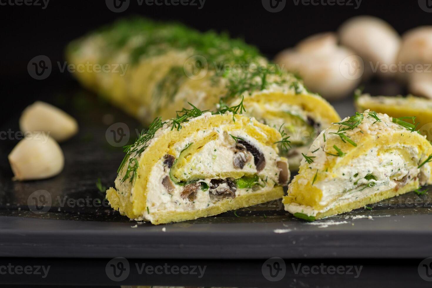 baked potato roll with cottage cheese filling with garlic and mushrooms, isolated on black background photo
