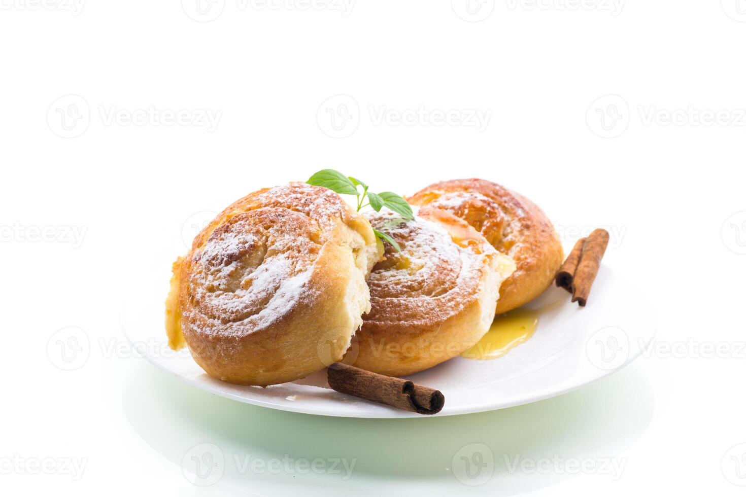Baked goods. Sweet buns with cottage cheese filling and honey in a plate isolated on a white background photo
