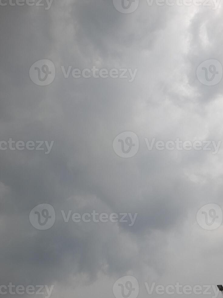 an overcast sky dominated by dense gray clouds, creating a moody and atmospheric scene. The soft light filtering through the clouds hints at possible rain or stormy weather. photo