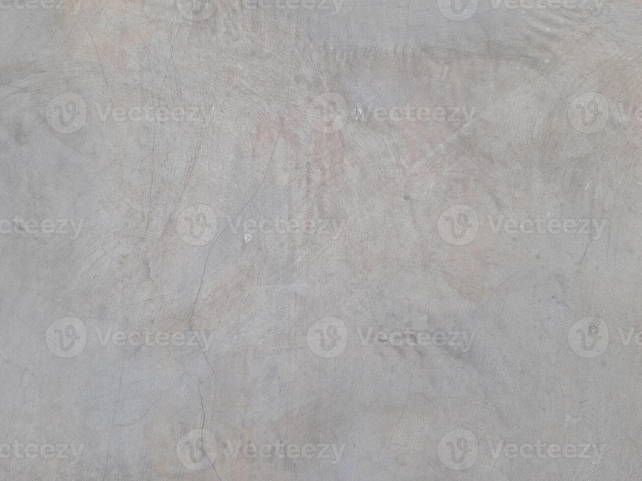 A plain gray textured surface with subtle irregular patterns and faint lines. The surface has a smooth yet natural appearance, resembling concrete or plaster with slight imperfections. photo