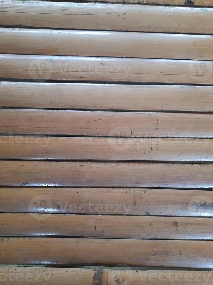 a horizontal arrangement of bamboo slats with a natural finish. The texture is rough and natural, emphasizing the raw characteristics of bamboo. photo