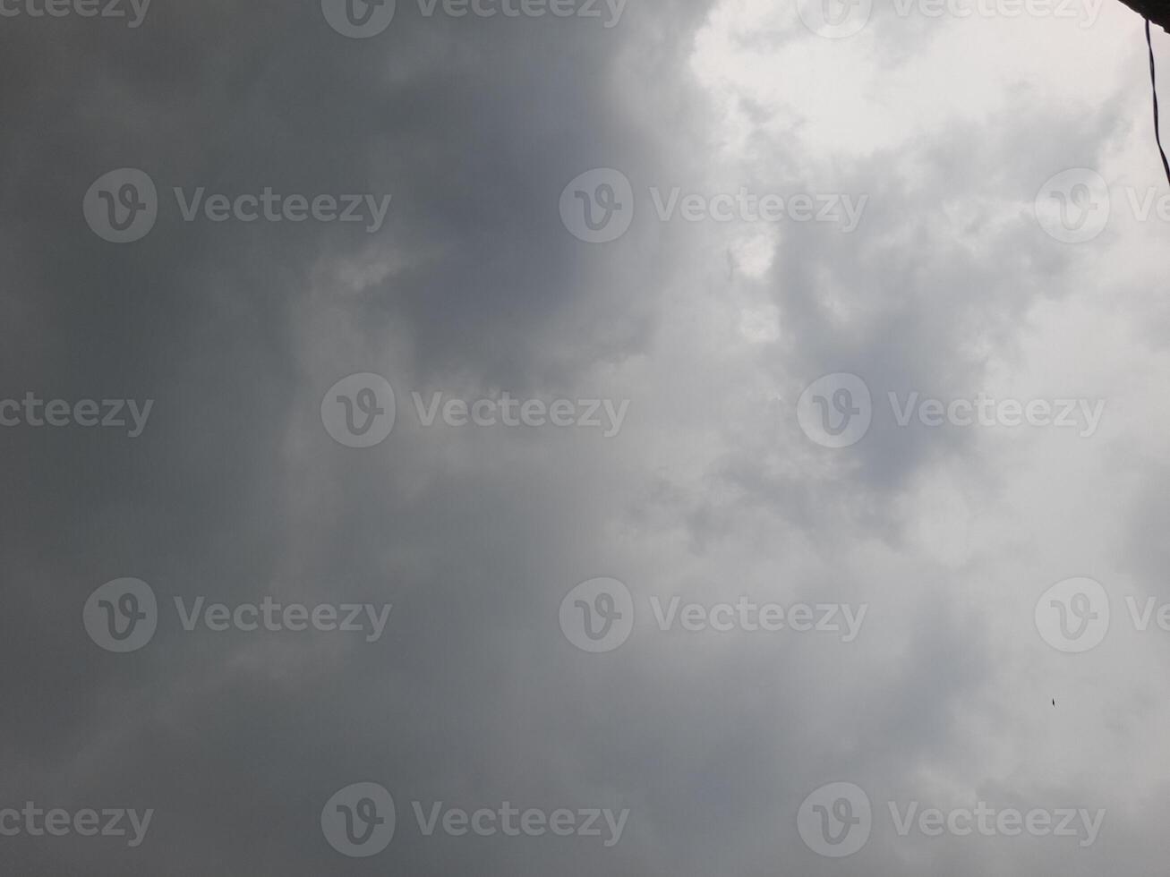 an overcast sky dominated by dense gray clouds, creating a moody and atmospheric scene. The soft light filtering through the clouds hints at possible rain or stormy weather. photo
