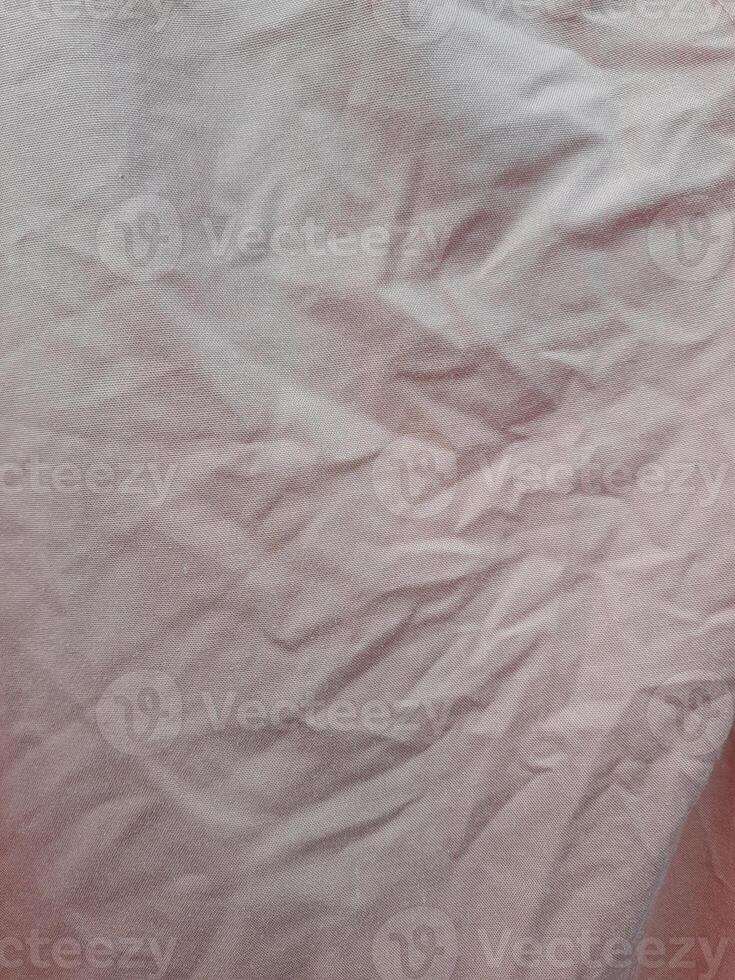 a khaki cloth with wrinkles and folds, illuminated by natural light, creating shadows and highlighting the texture of the fabric. photo