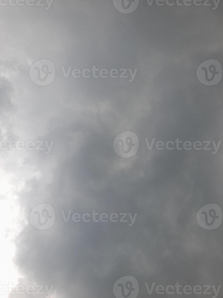 an overcast sky dominated by dense gray clouds, creating a moody and atmospheric scene. The soft light filtering through the clouds hints at possible rain or stormy weather. photo