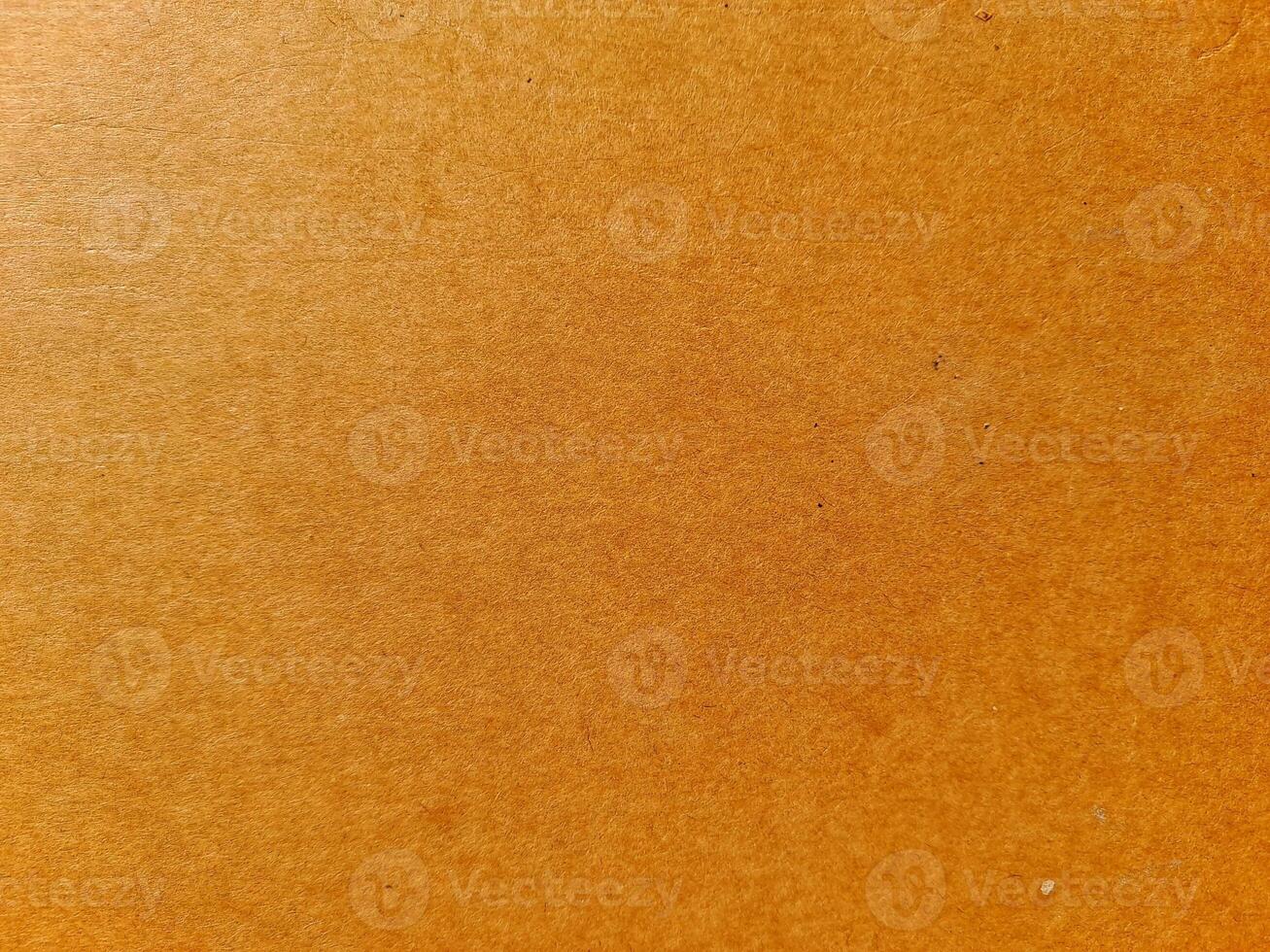 a brown cardboard surface with a characteristic texture. The brown tone is warm and natural, reflecting a simple and eco-friendly material. photo